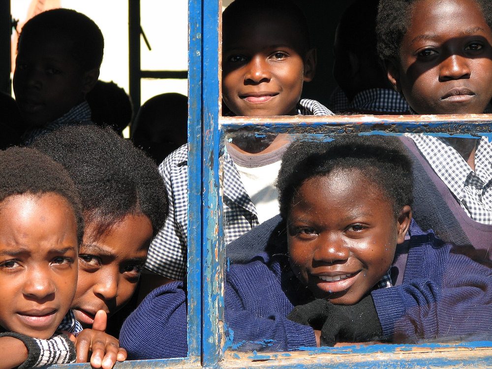 Pupils at the window of a rural primary school classroom